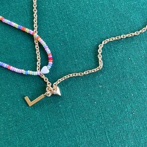 2 necklaces 1 w/ a ❤️ and bright and 1 w/ fake gold color and a L and a small ❤️